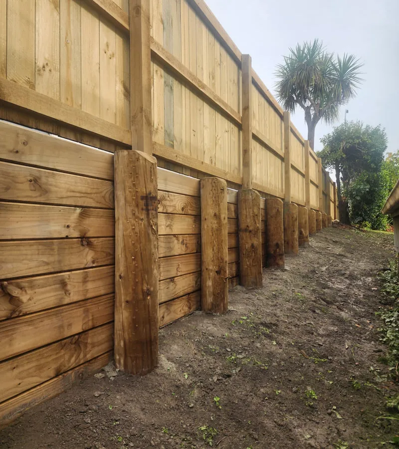 Professional retaining wall construction showing quality timber wall and proper drainage installation for slope stabilization in Nelson Tasman